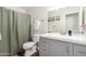 Charming bathroom with a shower and tub combination, gray vanity with white countertop, and a toilet at 11473 W Austin Thomas Dr, Surprise, AZ 85378