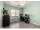 Bright bedroom with a ceiling fan, a large window with blinds, and tile flooring at 11473 W Austin Thomas Dr, Surprise, AZ 85378