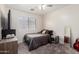 Cozy bedroom with neutral carpet, a ceiling fan, a side table and a black tv on a dresser at 11473 W Austin Thomas Dr, Surprise, AZ 85378