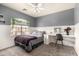 Well-lit bedroom with a ceiling fan, a vanity, a leafy plant hanging on the window, and soft carpet at 11473 W Austin Thomas Dr, Surprise, AZ 85378