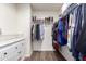 Walk-in closet with custom shelving, hanging racks, and a dresser with wood-look flooring at 11473 W Austin Thomas Dr, Surprise, AZ 85378