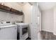 Functional laundry room with modern washer and dryer units and extra storage shelves above at 11473 W Austin Thomas Dr, Surprise, AZ 85378