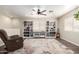 Spacious living room with custom built-ins, neutral rug, hardwood flooring, and a ceiling fan at 11473 W Austin Thomas Dr, Surprise, AZ 85378