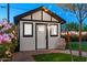 Charming shed with string lights in the backyard, surrounded by lush greenery and a barrel at 11530 E Vine Ave, Mesa, AZ 85208