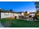 Expansive backyard with patio, grill, lush green lawn, and charming shed at dusk at 11530 E Vine Ave, Mesa, AZ 85208