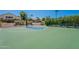 Outdoor basketball court with green and blue painted surface, surrounded by mature landscaping and tennis courts at 11675 E Caron St, Scottsdale, AZ 85259