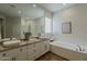 Elegant bathroom with double vanity, granite countertops, and soaking tub at 11675 E Caron St, Scottsdale, AZ 85259