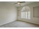 Bright bedroom with a neutral color palette, carpet flooring, and arched window with plantation shutters at 11675 E Caron St, Scottsdale, AZ 85259