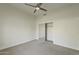 Minimalist bedroom with carpet floors, ceiling fan, and a mirrored closet door for added depth at 11675 E Caron St, Scottsdale, AZ 85259