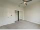 Minimalist bedroom with carpet floors, ceiling fan, and a mirrored closet door for added depth and style at 11675 E Caron St, Scottsdale, AZ 85259