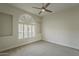 Bright bedroom with a neutral color palette, carpet flooring, and arched window with plantation shutters at 11675 E Caron St, Scottsdale, AZ 85259