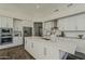 Modern kitchen boasts white cabinets, stainless steel appliances, and a large center island at 11675 E Caron St, Scottsdale, AZ 85259