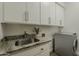 Functional laundry room with granite countertop, stainless steel sink, and modern washer for convenience at 11675 E Caron St, Scottsdale, AZ 85259