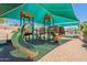 Well-maintained playground with slides, climbing structures, and shade canopies set on a soft, sandy base at 11675 E Caron St, Scottsdale, AZ 85259