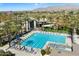 Beautiful, bright swimming pool with lap lanes and lounge chairs under blue umbrellas, set among lush landscaping at 11675 E Caron St, Scottsdale, AZ 85259
