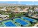 Aerial view of pristine blue and green tennis courts in a well-maintained community, with mountain views at 11675 E Caron St, Scottsdale, AZ 85259