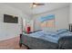 Bright bedroom features a ceiling fan, TV, and a door leading to another room at 12416 W Midway Ave, Glendale, AZ 85307