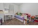 Cozy bedroom with a single bed, window, desk, and organized storage unit at 12416 W Midway Ave, Glendale, AZ 85307
