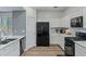 Cozy kitchen featuring black appliances, sleek white cabinets, modern countertops, and wood-look flooring at 12416 W Midway Ave, Glendale, AZ 85307