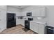 Bright kitchen space showcasing white cabinets, stainless steel appliances and wood-look vinyl floors at 12416 W Midway Ave, Glendale, AZ 85307