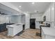 Updated kitchen with stainless steel appliances, white cabinets, and wood floors leading into the living space at 12416 W Midway Ave, Glendale, AZ 85307