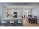 Bright kitchen showcasing white cabinetry, stainless steel appliances, an island with barstool seating, and wood flooring at 12416 W Midway Ave, Glendale, AZ 85307