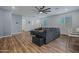 Well-lit living room featuring wood floors and a dark gray sectional sofa at 12416 W Midway Ave, Glendale, AZ 85307