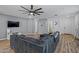 Open concept living room with a gray sectional sofa and wood-look floors at 12416 W Midway Ave, Glendale, AZ 85307