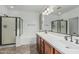 Bright bathroom featuring dual vanities, a soaking tub, and a glass enclosed shower at 13446 S 186Th Ave, Goodyear, AZ 85338