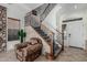Inviting foyer with a staircase featuring wrought iron railings, stone accent wall, and natural light at 13446 S 186Th Ave, Goodyear, AZ 85338