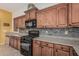 Modern kitchen featuring sleek wooden cabinets, granite countertops, and stainless-steel appliances at 13446 S 186Th Ave, Goodyear, AZ 85338