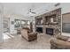 Bright living room with a stone fireplace, ceiling fan, tile flooring, and large windows at 13446 S 186Th Ave, Goodyear, AZ 85338