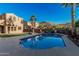 Inviting pool with a view of the desert mountain, palm trees, and houses in the backyard under a bright, blue sky at 13446 S 186Th Ave, Goodyear, AZ 85338