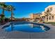 A serene blue pool is surrounded by desert landscaping and palm trees in this backyard with a built-in barbeque at 13446 S 186Th Ave, Goodyear, AZ 85338