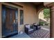 Cozy front porch with decorative door, comfortable seating area, and a colorful outdoor rug at 13446 S 186Th Ave, Goodyear, AZ 85338