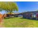 Backyard featuring mature trees, lush lawn, and dark-painted exterior at 1527 E Sunnyslope Ln, Phoenix, AZ 85020