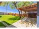 Beautiful backyard featuring green lawn, mature tree, custom stone and wood fence and covered patio at 1527 E Sunnyslope Ln, Phoenix, AZ 85020