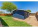 An appealing backyard featuring lush green grass and partial view of the house with a blue exterior at 1527 E Sunnyslope Ln, Phoenix, AZ 85020