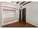 Bedroom with built-in shelves, storage bench, hardwood floors, and a rustic door at 1527 E Sunnyslope Ln, Phoenix, AZ 85020