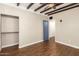 Bedroom featuring exposed beam ceilings, hardwood floors, and a blue paneled door at 1527 E Sunnyslope Ln, Phoenix, AZ 85020