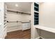 Spacious walk-in closet with custom shelving, hanging racks, built-in desk and white dresser at 1527 E Sunnyslope Ln, Phoenix, AZ 85020