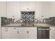 Close up of white kitchen cabinets, sink and backsplash. Includes stainless steel dishwasher at 1527 E Sunnyslope Ln, Phoenix, AZ 85020