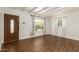 Open-concept living area featuring wood-look floors, white walls, a detailed front door and bright natural light at 1527 E Sunnyslope Ln, Phoenix, AZ 85020
