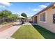 Spacious backyard featuring a brick patio, artificial grass and wrought iron fence at 15704 W Taylor St, Goodyear, AZ 85338