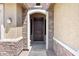 Elegant front entry with a stone surround, solid wood door, and stylish lighting enhances the home's curb appeal at 15704 W Taylor St, Goodyear, AZ 85338