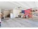 View of a large two car garage with shelving, plenty of storage and an American flag at 15704 W Taylor St, Goodyear, AZ 85338