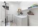 Laundry room with side by side washer and dryer, overhead shelving, and ample room to complete laundry tasks at 15704 W Taylor St, Goodyear, AZ 85338