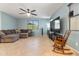 Comfortable living room features tile floors, a ceiling fan, and lots of natural light at 15704 W Taylor St, Goodyear, AZ 85338