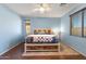 Bright main bedroom featuring wood floors, ceiling fan, and natural light from two windows at 15704 W Taylor St, Goodyear, AZ 85338