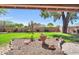 Lush backyard featuring desert landscaping, mature trees, privacy fence, and a covered patio at 17705 E Canyon Way, Gilbert, AZ 85298